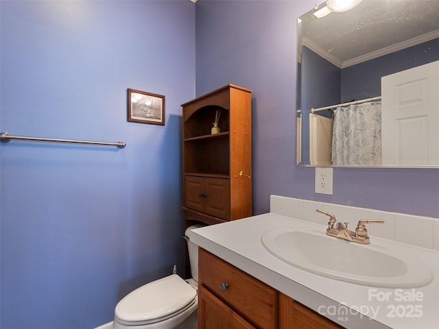 full bathroom with vanity, toilet, ornamental molding, and curtained shower