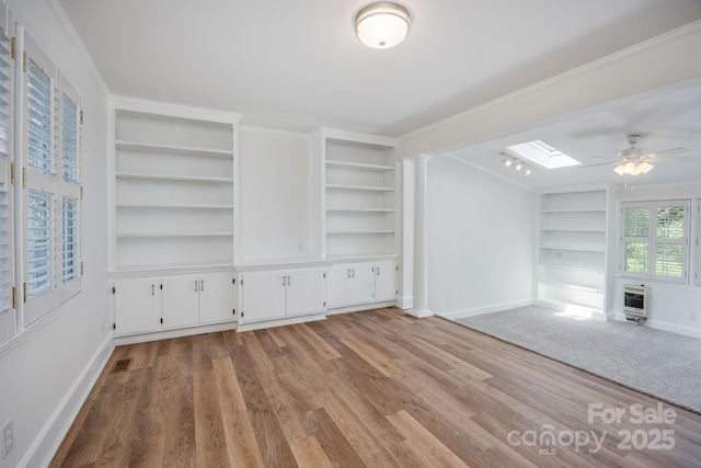402 Hudson St, Winnsboro, SC 29180 - unfurnished living room with built in shelves, baseboards, heating unit, and a skylight