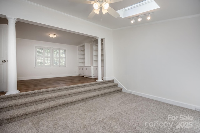 402 Hudson St, Winnsboro, SC 29180 - empty room with a ceiling fan, a skylight, baseboards, ornamental molding, and ornate columns