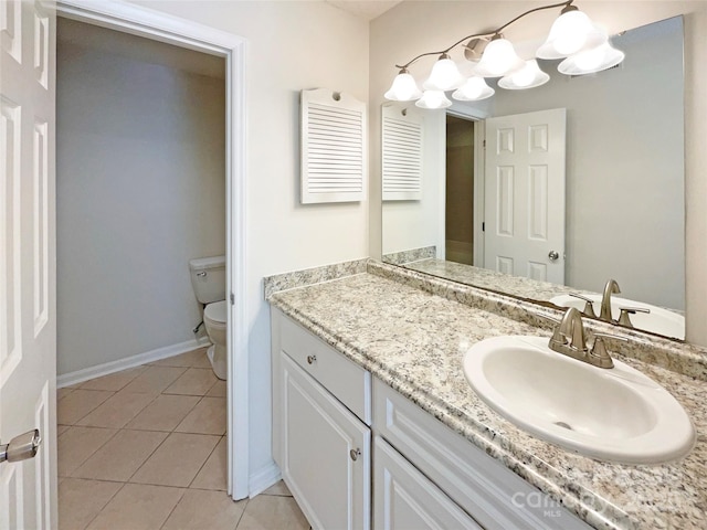 bathroom with vanity, toilet, tile patterned flooring, and baseboards