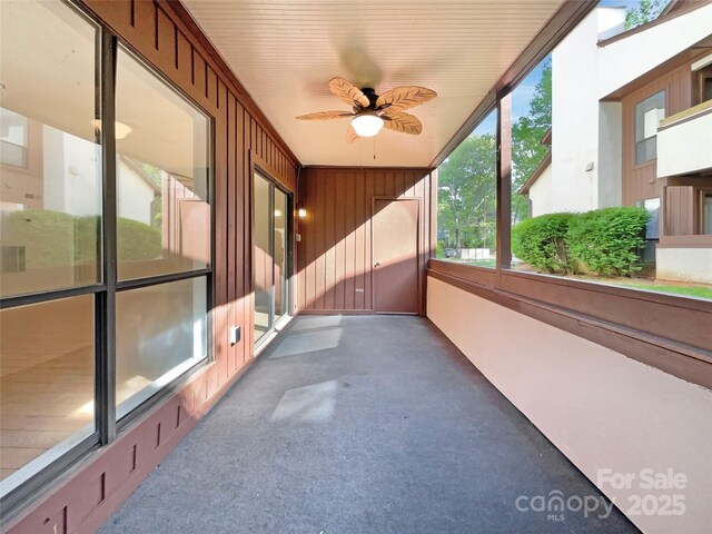 unfurnished sunroom featuring a ceiling fan