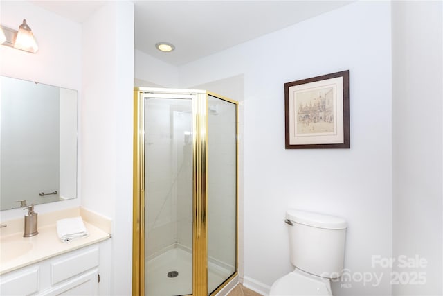 bathroom with toilet, vanity, and a stall shower