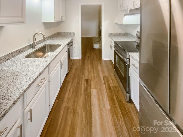 8026 Regent Park Ln, Charlotte, NC 28210 - kitchen with appliances with stainless steel finishes, a sink, under cabinet range hood, wood finished floors, and white cabinets