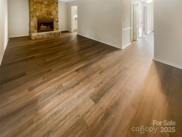 8026 Regent Park Ln, Charlotte, NC 28210 - unfurnished living room with wood finished floors, a stone fireplace, and baseboards