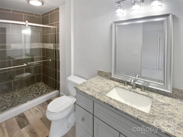 8026 Regent Park Ln, Charlotte, NC 28210 - bathroom featuring toilet, vanity, a stall shower, and wood finished floors