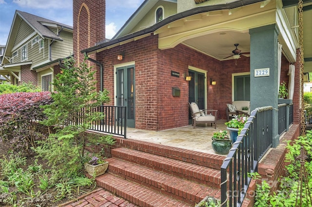 back of house with a chimney, brick siding, and ceiling fan
