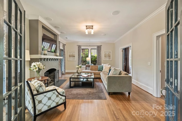 living room featuring crown molding, wood finished floors, french doors, baseboards, and a brick fireplace