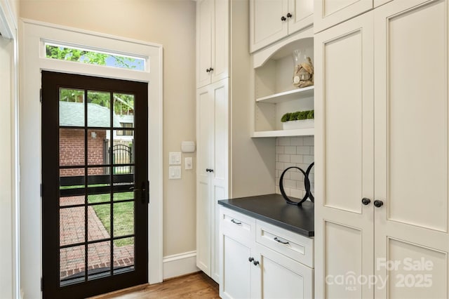 entryway with light wood-style flooring and baseboards