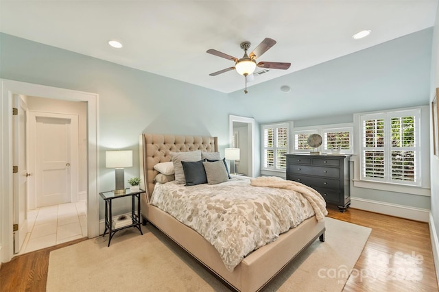 bedroom featuring vaulted ceiling, wood finished floors, visible vents, a ceiling fan, and baseboards