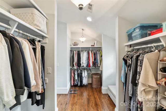 spacious closet featuring lofted ceiling, wood finished floors, and visible vents