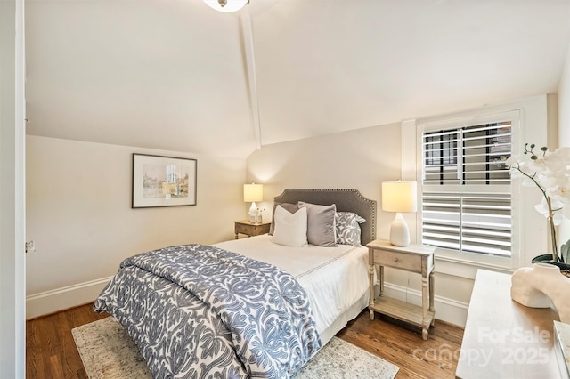 bedroom featuring baseboards, vaulted ceiling, and wood finished floors