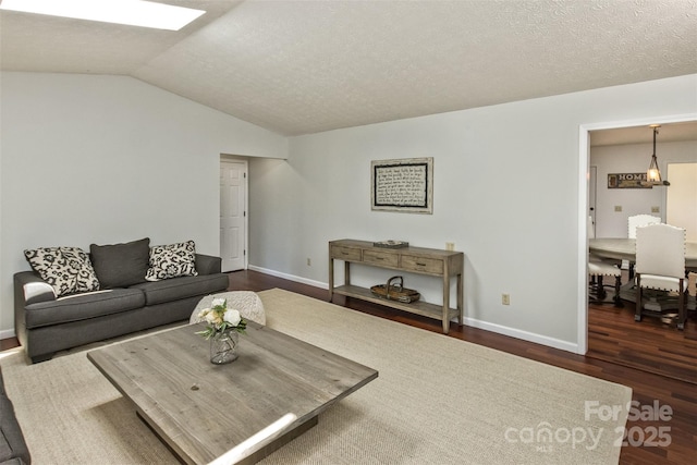 147 Canaan Dr, Candler, NC 28715 - living area with vaulted ceiling, dark wood-type flooring, a textured ceiling, and baseboards