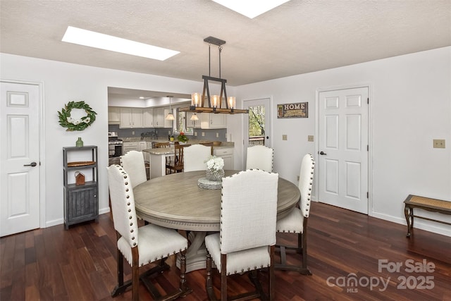 147 Canaan Dr, Candler, NC 28715 - dining area with baseboards, a textured ceiling, a chandelier, and dark wood finished floors