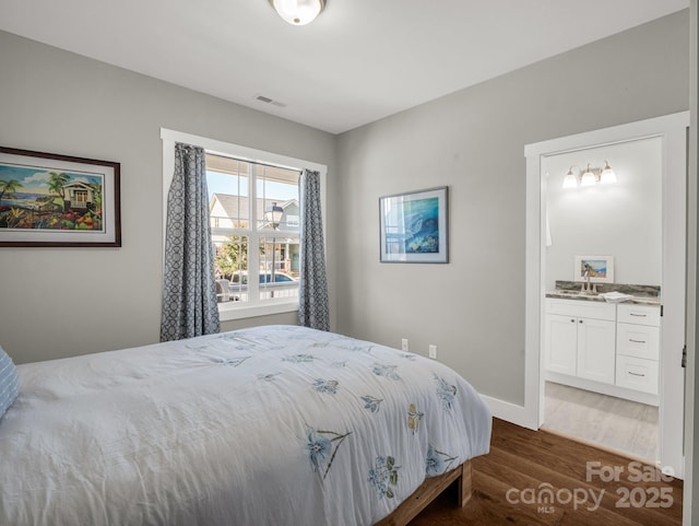231 Leyland Cir, Hendersonville, NC 28792 - bedroom featuring wood finished floors, a sink, ensuite bathroom, and baseboards