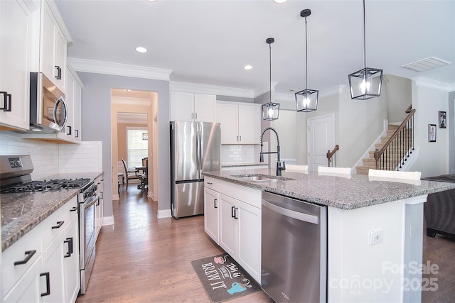 2014 Burton Point Ct, Waxhaw, NC 28173 - kitchen with stainless steel appliances, an island with sink, backsplash, pendant lighting, and light stone counters