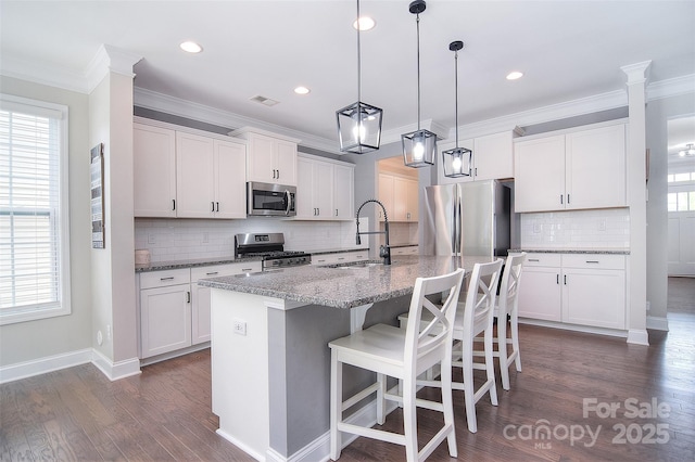 2014 Burton Point Ct, Waxhaw, NC 28173 - kitchen featuring stainless steel appliances, decorative backsplash, dark wood finished floors, an island with sink, and a breakfast bar