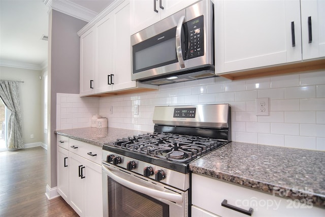 2014 Burton Point Ct, Waxhaw, NC 28173 - kitchen featuring appliances with stainless steel finishes, crown molding, dark stone counters, tasteful backsplash, and wood finished floors