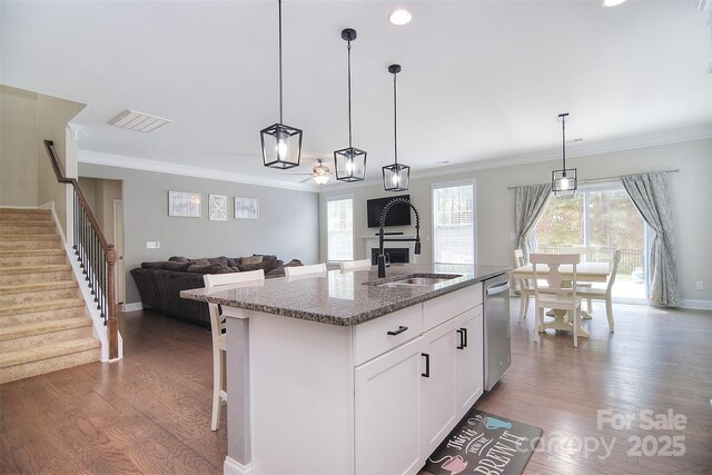 2014 Burton Point Ct, Waxhaw, NC 28173 - kitchen featuring dishwasher, wood finished floors, light stone countertops, a kitchen island with sink, and white cabinetry