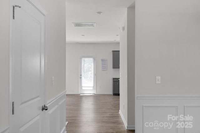 corridor with visible vents, baseboards, and dark wood finished floors