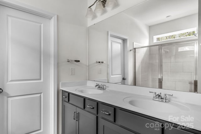 full bath featuring a sink, double vanity, and tiled shower