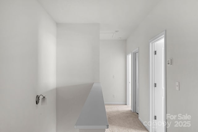 hall featuring baseboards and light carpet
