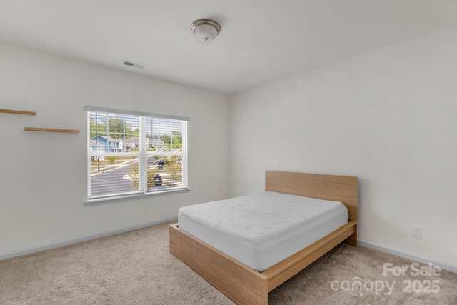 carpeted bedroom with visible vents and baseboards