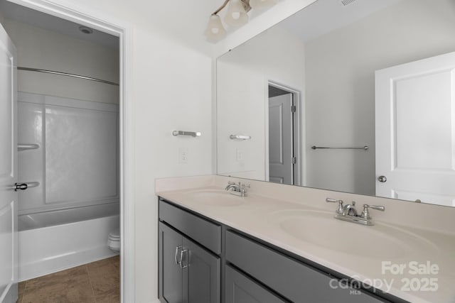 full bathroom featuring double vanity, toilet, shower / bathtub combination, and a sink
