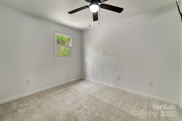 empty room featuring crown molding, a ceiling fan, baseboards, and carpet