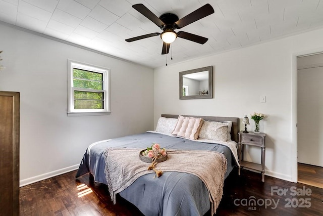 bedroom with baseboards, a ceiling fan, wood finished floors, and ornamental molding