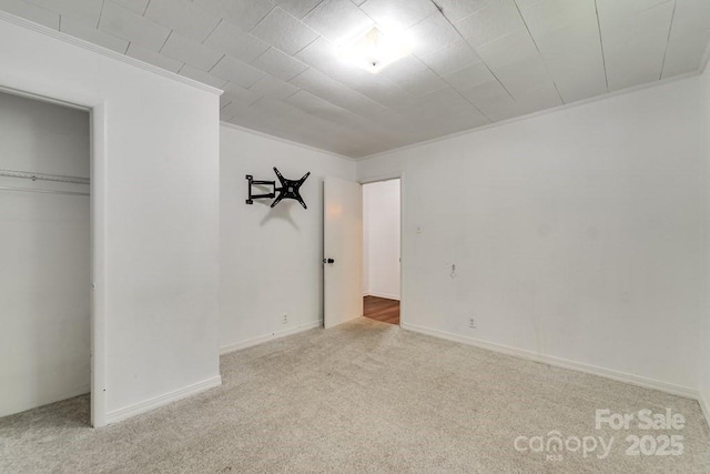 unfurnished bedroom featuring carpet floors, ornamental molding, and a closet