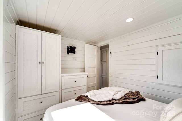 bedroom featuring wooden walls and wood ceiling