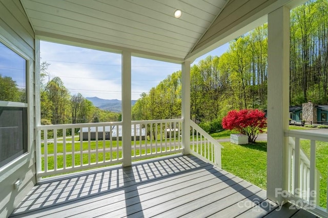wooden terrace featuring a lawn and a mountain view