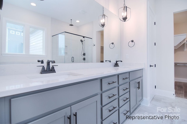 bathroom with double vanity, a sink, marble finish floor, and a stall shower