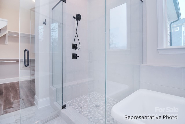 full bath with a freestanding tub and a stall shower