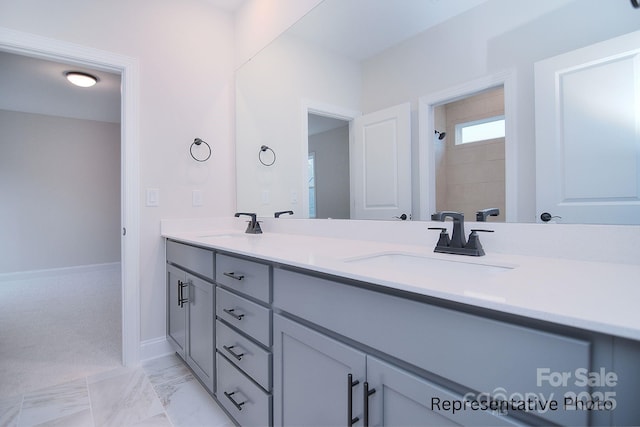 bathroom featuring a sink, a tile shower, double vanity, and marble finish floor