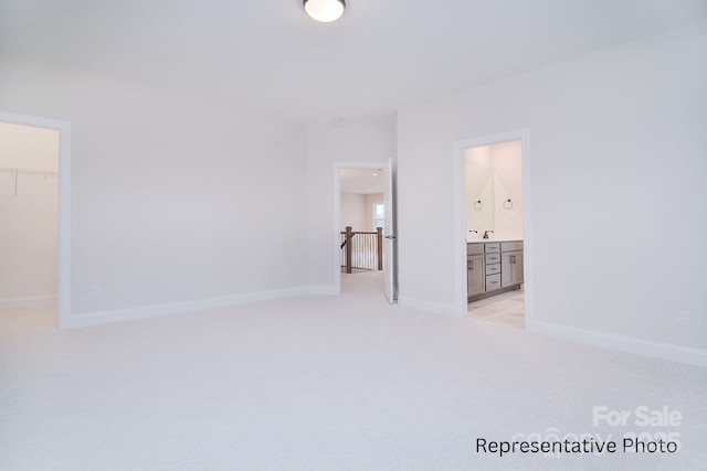 spare room featuring baseboards and light carpet