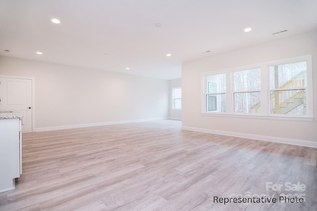 unfurnished living room with recessed lighting and light wood-type flooring