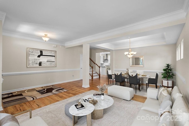 living room with crown molding, stairs, and wood finished floors