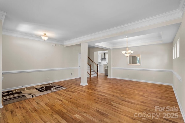 interior space featuring crown molding, stairs, wood finished floors, and a chandelier