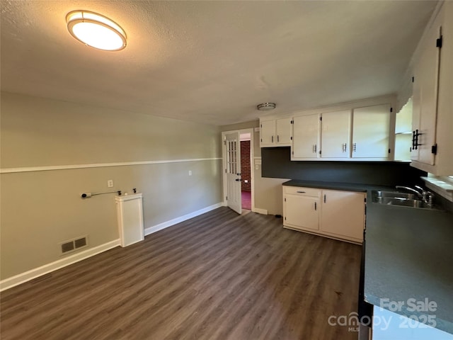 2703 34th Street Pl NE, Hickory, NC 28601 - kitchen featuring dark wood-style floors, a sink, baseboards, visible vents, and white cabinetry