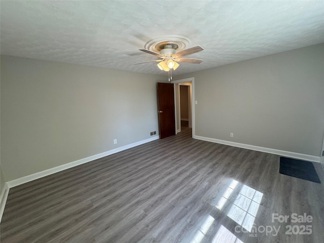 2703 34th Street Pl NE, Hickory, NC 28601 - empty room featuring a textured ceiling, dark wood-style flooring, baseboards, and ceiling fan