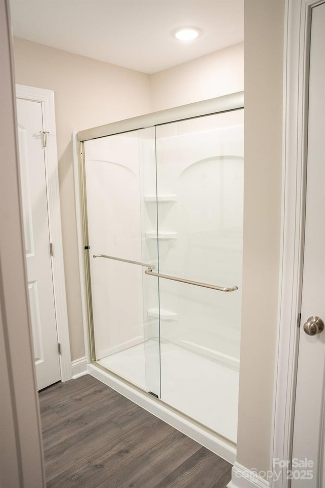 full bath with wood finished floors, recessed lighting, and a shower stall