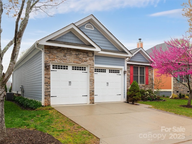 single story home with a garage, stone siding, and concrete driveway