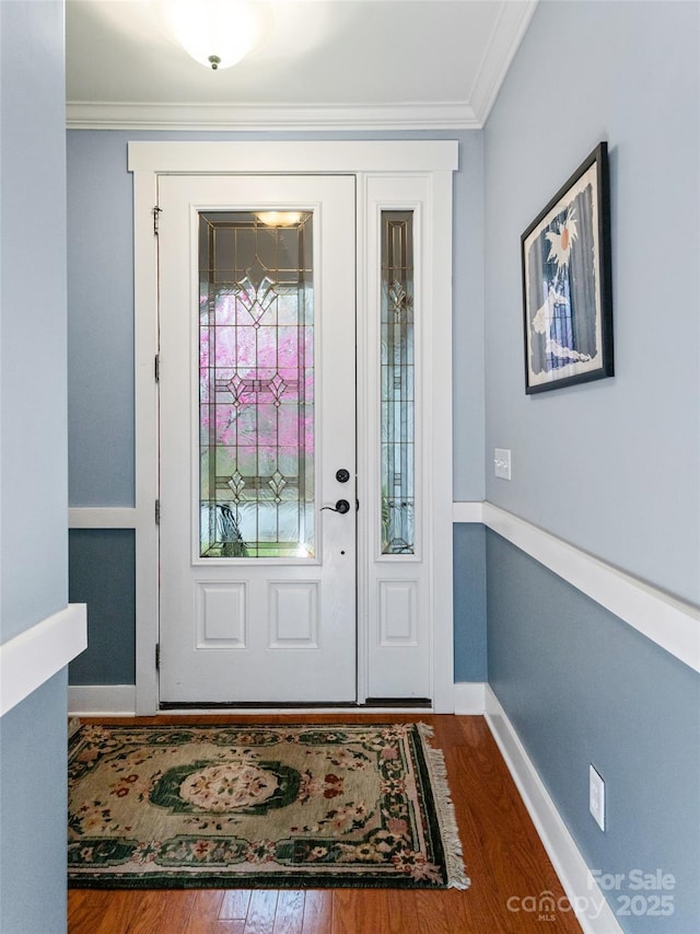 foyer entrance with baseboards, ornamental molding, and wood finished floors