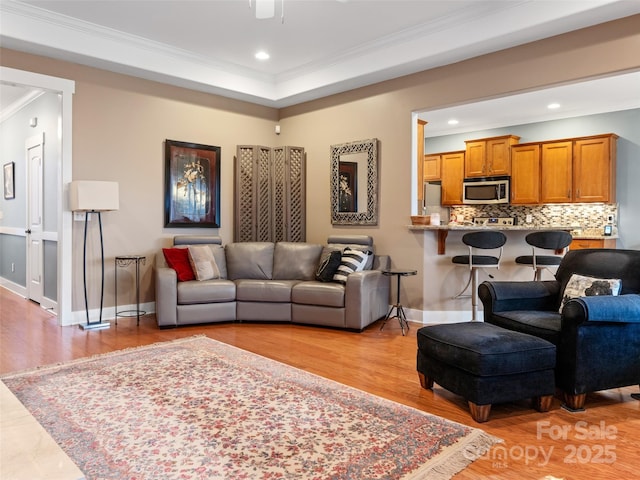 living room featuring a ceiling fan, recessed lighting, light wood-style floors, and crown molding