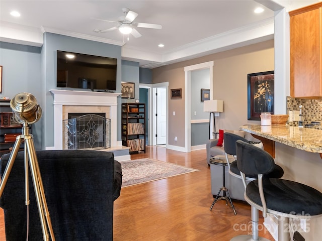 living room featuring a ceiling fan, recessed lighting, light wood-style floors, and crown molding