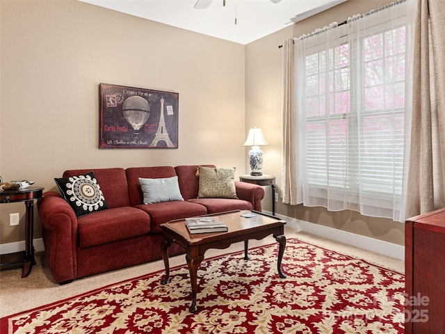 carpeted living room with baseboards and ceiling fan