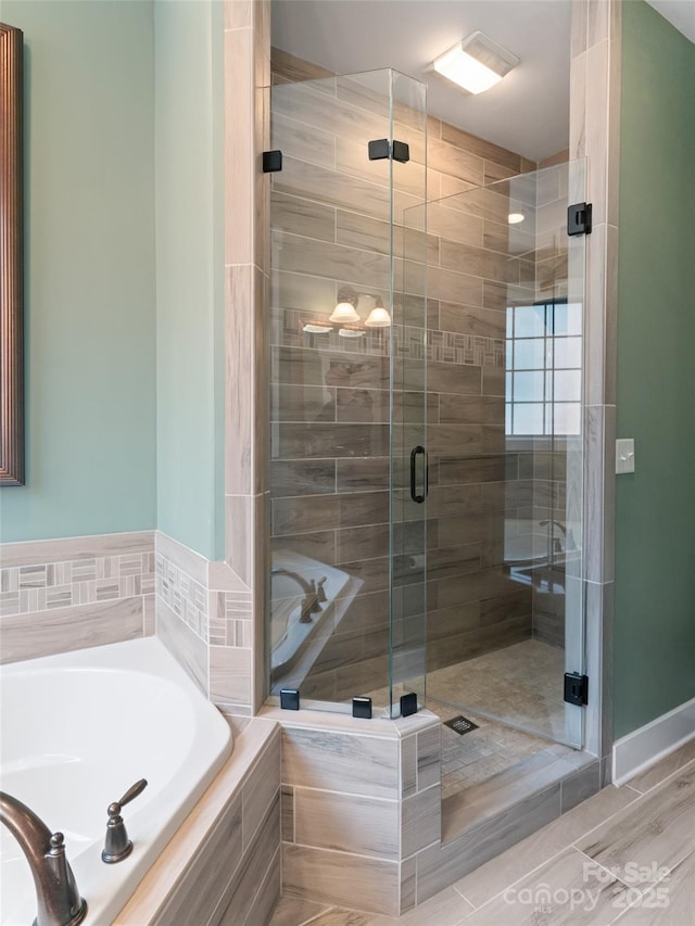full bathroom with a bath and a shower stall