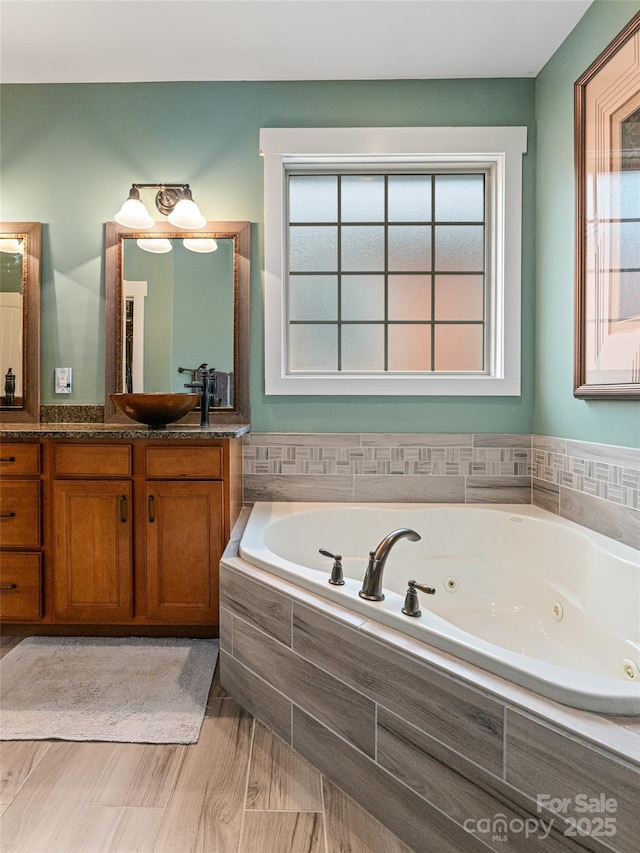 bathroom with a jetted tub and vanity