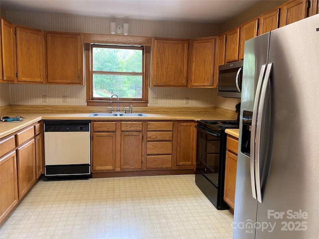 kitchen featuring a sink, light floors, brown cabinetry, light countertops, and appliances with stainless steel finishes